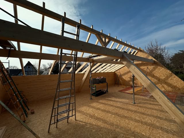 Charpente bois en cours de montage avec ses étais et son matériel de chantier